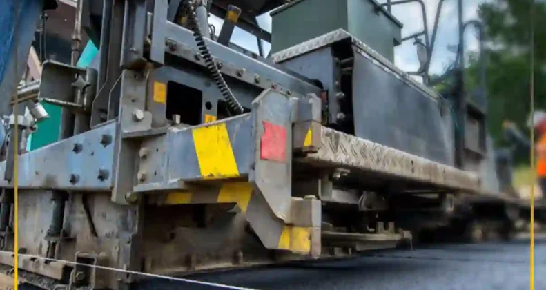 Heavy asphalt paver machine laying high-quality polymer modified bitumen ensuring excellent compatibility and road durability