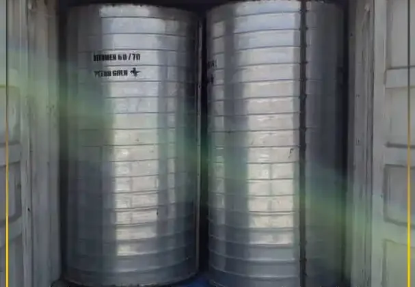 Securely packed 185kg metal drums inside a shipping container ensuring long-term bitumen storage stability during global export