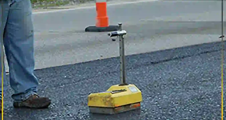 Site engineer using compaction testing equipment for asphalt quality control to ensure reliable pavement durability and structural integrity