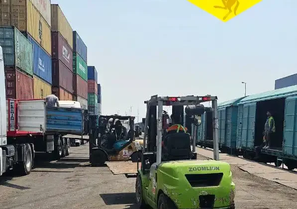 Forklift loading bitumen cargo into railway wagons for international overland export and logistics