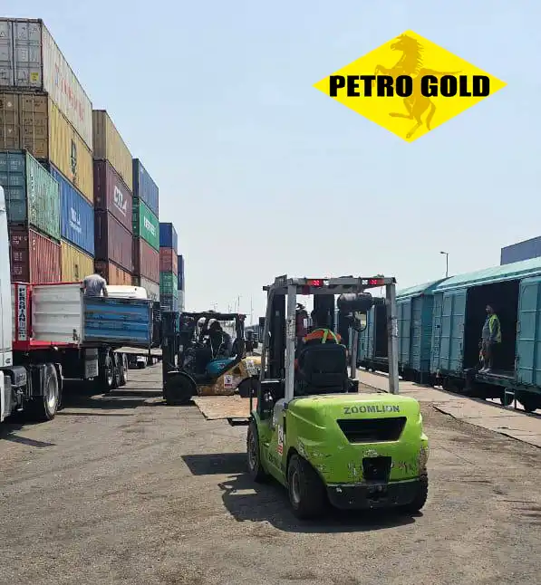 Forklift loading bitumen cargo into railway wagons for international overland export and logistics